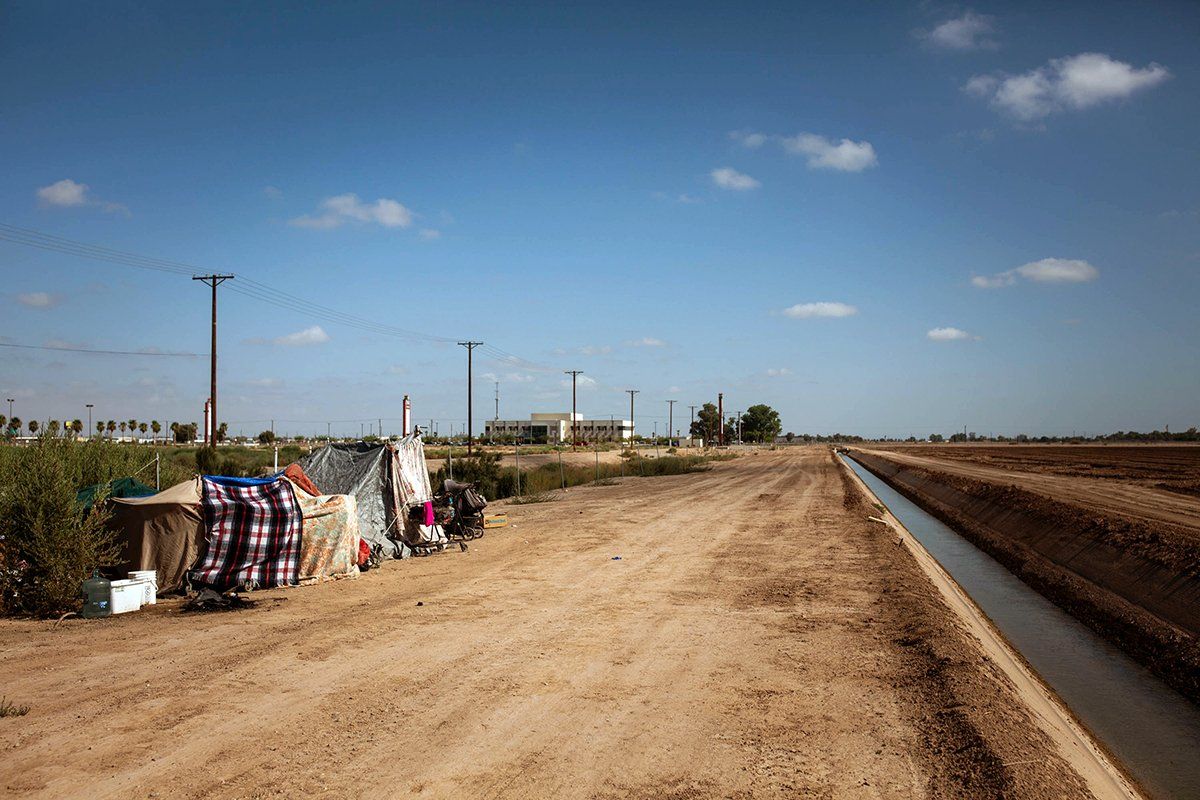 A homeless encampment near a canal in El Centro, Calif., as seen on July 24, 2020. As support services have dwindled amid the COVID-19 pandemic, some homeless people in Imperial County have resorted to bathing in irrigation canals. Homelessness looks different in different parts of the U.S., especially in rural agricultural regions such as Imperial County. Image by Anna Maria Barry-Jester/KHN. United States, 2020.
