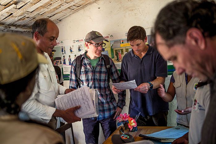 Country Director Mohammed Ali Ouenzar and co-founders Jim Herrnstein, Matt Bonds, and Michael Rich (left to right) inspect the ledgers at a local health post as part of PIVOT's intense focus on data. Image by Rijasolo. Madagascar, 2019.