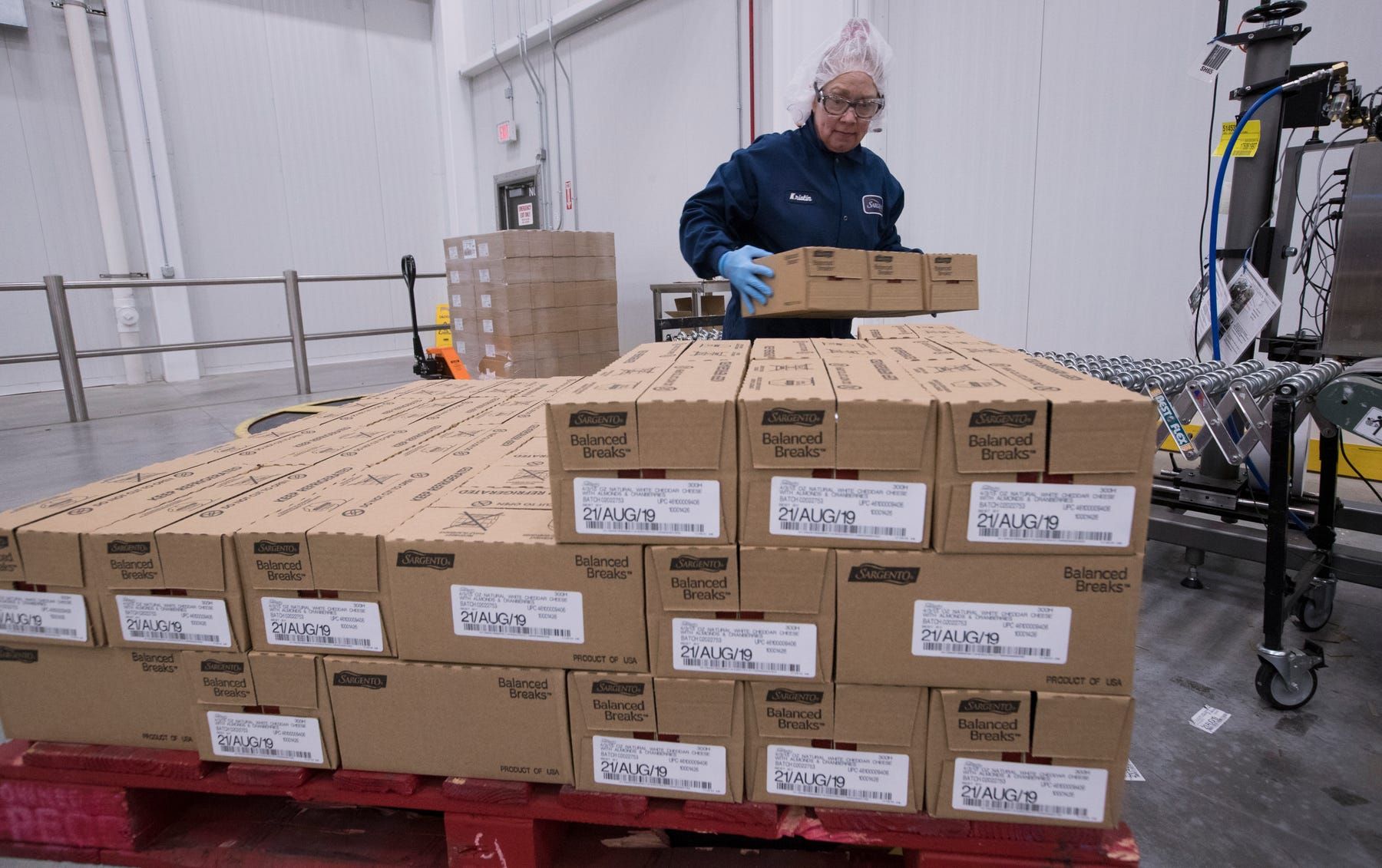 Kathy Griffey, top, and Kristin Geary, bottom right, work on an assembly line packaging Balanced Breaks snacks at Sargento Foods Inc. The company employs about 2,300 people in Wisconsin. Image Courtesy of Mark Hoffman. United States, 2019.