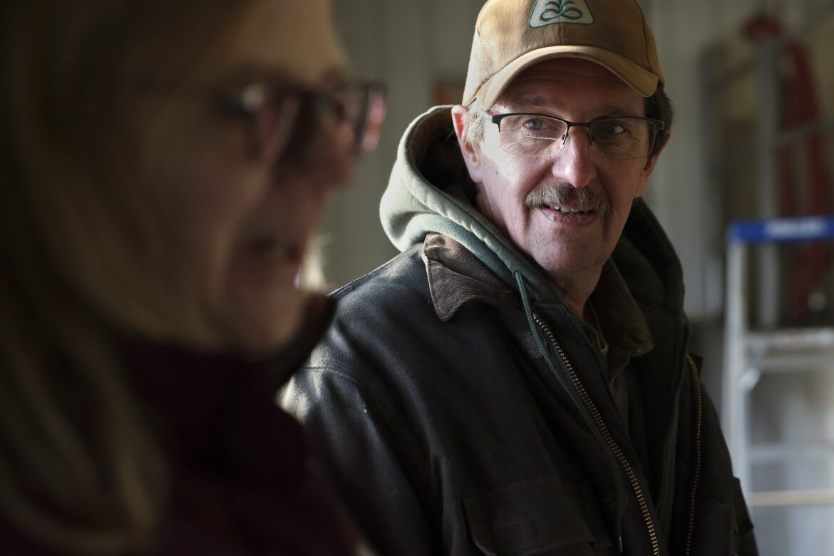 David and Amy Fischer stand together in the milking barn on their 350-cow dairy farm, Darian Acres, in Rio, Wis., on Dec. 18, 2020. Their son, Brian, died by suicide in 2016. “It don’t go away,” David Fischer said about the heartache he feels. “He should be here.” Image by Coburn Dukehart / Wisconsin Watch. United States, 2020.