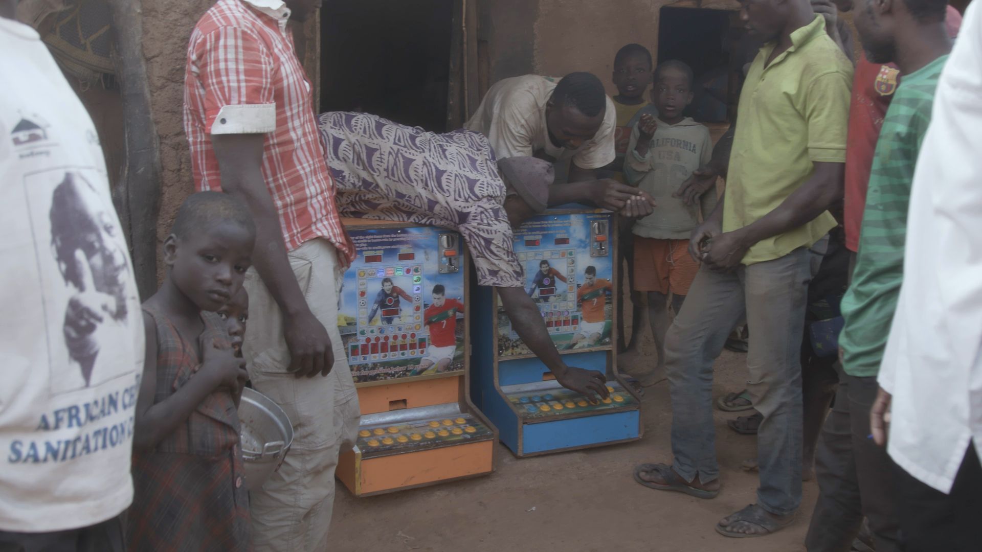 Villagers gamble at the machines in Zamashegu. Image by Noah Fowler. Ghana, 2017.
