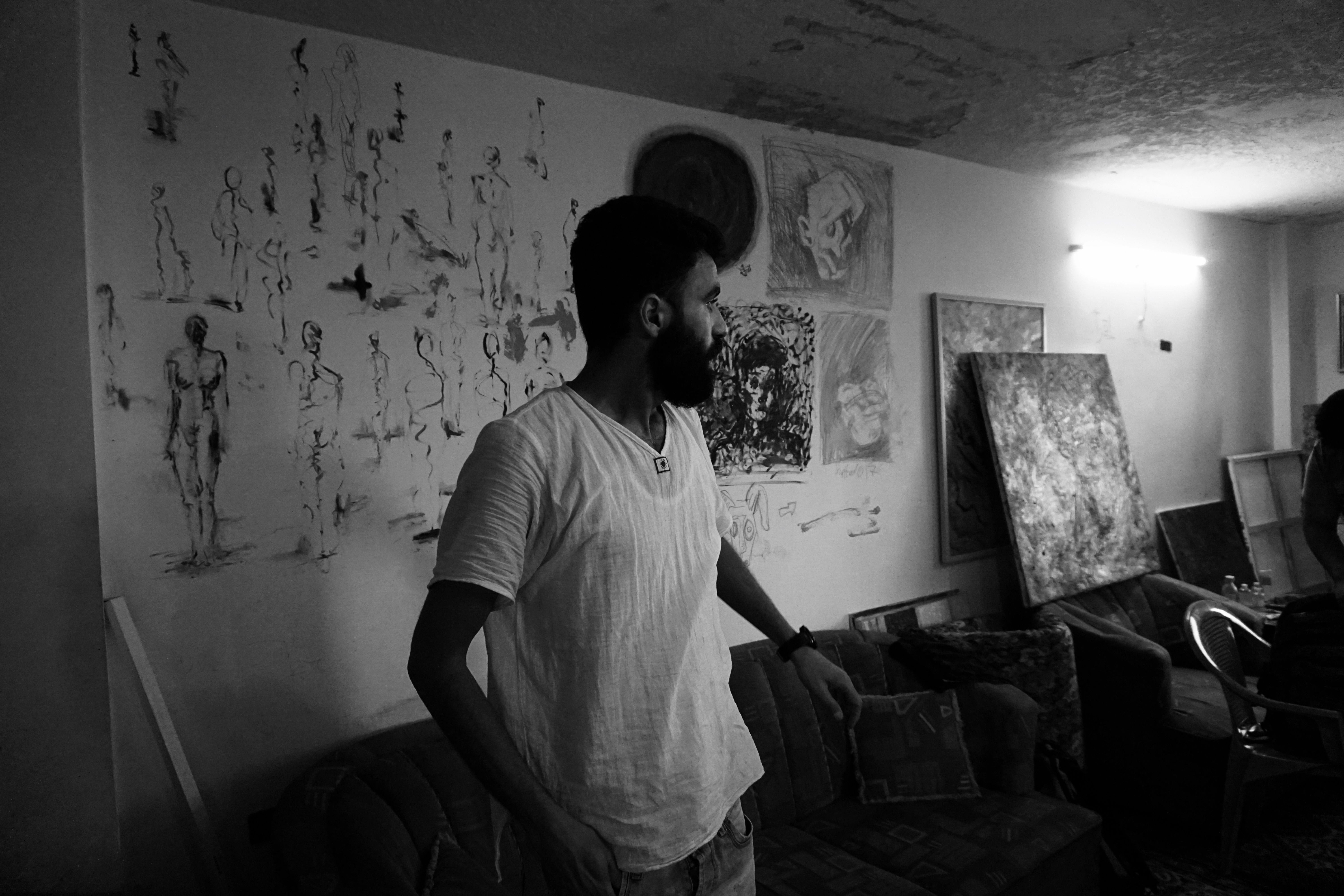 Emsallam Hdaib looks at his artwork in his Amman studio. Image by Aman Madan. Jordan, 2017.