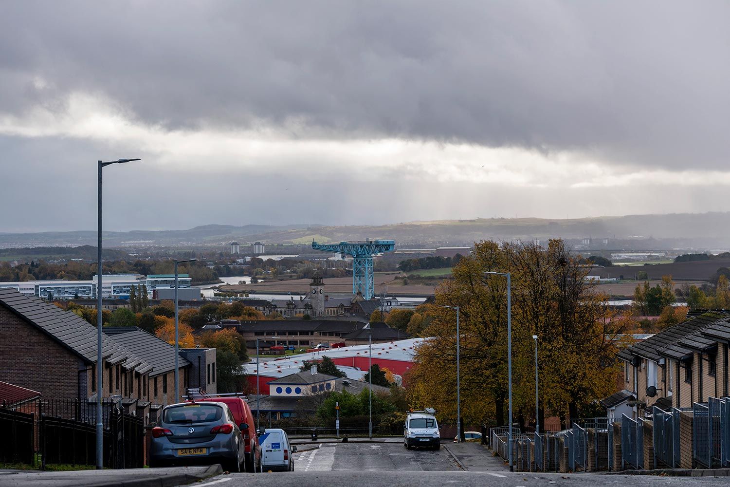 A giant blue crane known as “The Titan” hangs over the edge of town, in Clydebank, West Dunbartonshire, Scotland. Image by Michael Santiago. United Kingdom, 2019.