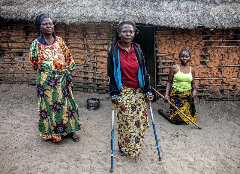 (From left) Cécile Mwandjombi and her two daughters, Nov Lutondo, 27, and Ruth Lutondo, 24, who have been disabled by konzo. Image by Neil Brandvold. DRC, 2017.
