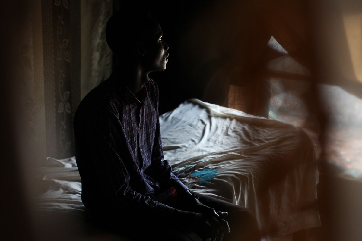 Y, 18, in his home in the POC in Juba, where he has been living since January 2018. He was going to school in Malakal when the war started. He fled to a village in Fangak where his family is originally from. 'When the enemy attacked us, I decided to join because I was angry. They killed old people, children, disabled people who could not escape. One of my cousins was killed. I knew that if they reach our village, they would kill my family, destroy our properties. I thought, it's better if I die fighting them then let them kill my parents.' At the beginning of this year, he asked to go to Juba. 'I didn't want to be there any more. The soldiers on both sides, it's not them, they could shake hands. But the big people make them fight.' Image by Andreea Campeanu. South Sudan, 2018.