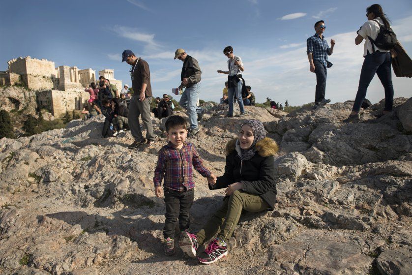 Syrian refugees Taima and her 3-year-old son, Wael, walk around the Acropolis in Athens. Image by Lynsey Addario. Greece, 2017.