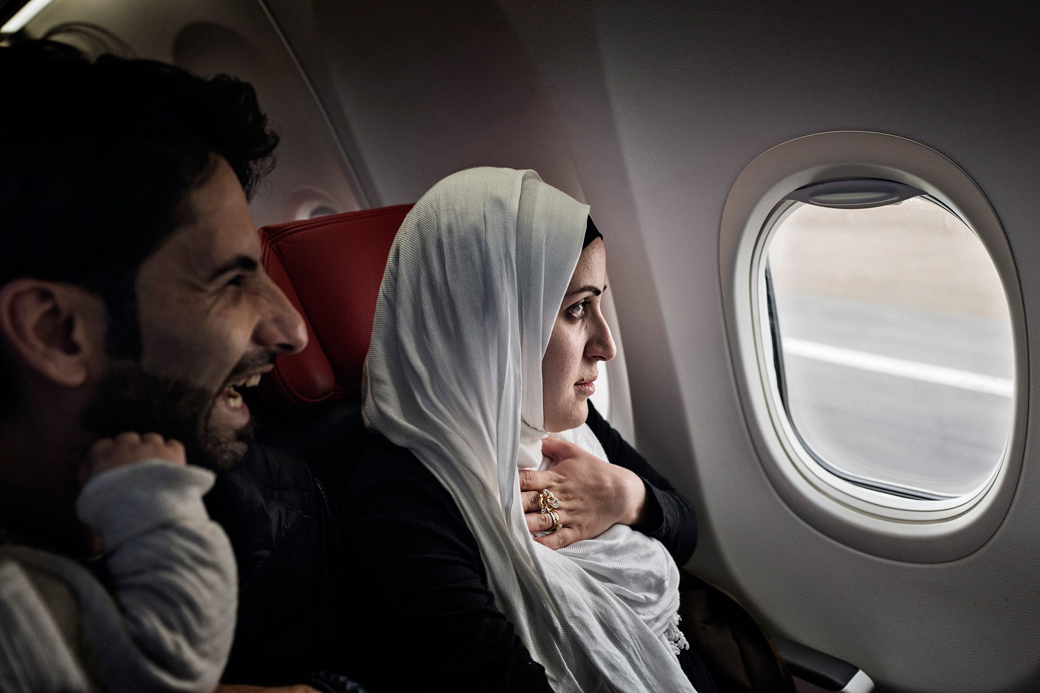 Syrian refugees Taimaa Abzali and her husband Muhanned Abzali, look out the window with a mix of fear and excitement as they see Estonia from the air for the first time. Image by Lynsey Addario. Estonia, 2017.
