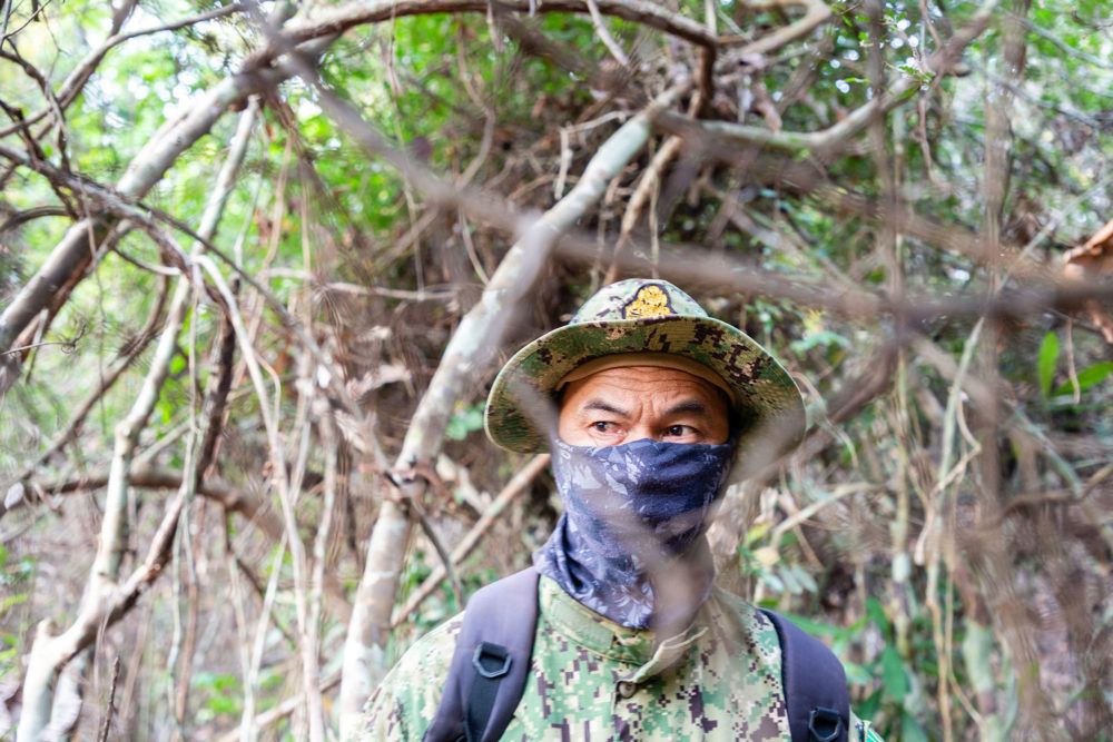 A Cambodian environmental ranger on patrol looking for illegal loggers in the Phnom Tnout Phnom Pok sanctuary. Some rangers hide their identity out of fear of reprisals from loggers and their allies in the police and military. Image by Sean Gallagher. Cambodia, 2020.

