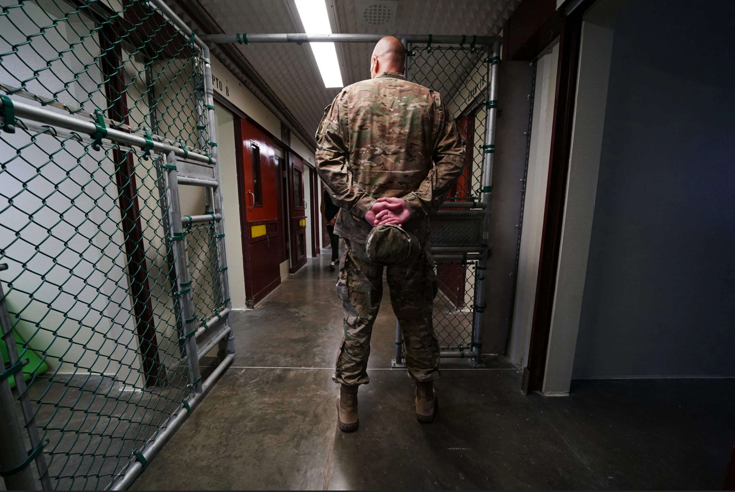 A member of the military at Guantanamo Bay’s detention center. For most of two decades, the United States has been holding five men accused of helping plot the September 11, 2001 attacks. Image by Doug Mills for The New York Times. United States, undated.