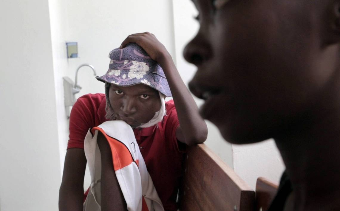 A dejected Djooly Jeune, 17, sits by his mother, Angena Altidor, after a nurse at the University Hospital of Mirebalais finally informs them that he would not be able to get his chemotherapy because of his blood work. Image by José A. Iglesias. Haiti, 2018.