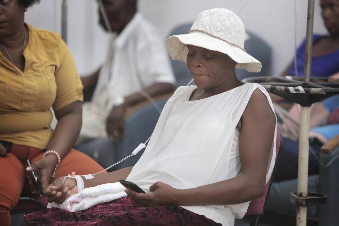 Cervical cancer patient, Guerda Janvier (center), 46, is getting hydrated at Innovating Health International in Port-au-Prince before her chemotherapy treatment. Image by José A. Iglesias. Haiti, 2018.