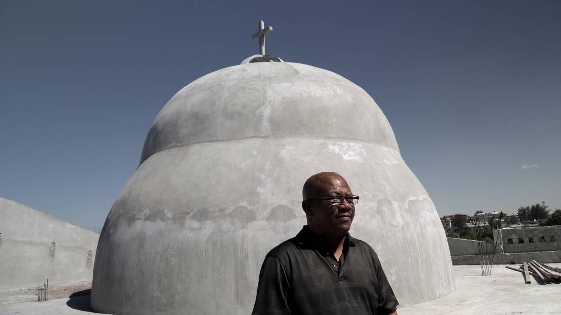 Father Jean Jacques Frédéric poses near the dome of Notre-Dame du Perpétuel Secours. Image by Jose A. Iglesias. Haiti, 2020.