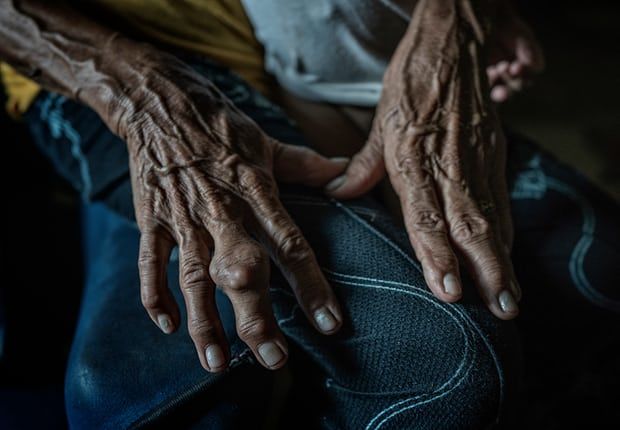 The hands of 85-year-old Remy Fernandez, who has looked after seven grandchildren since her son was killed. Image by James Whitlow Delano. Philippines, 2018.