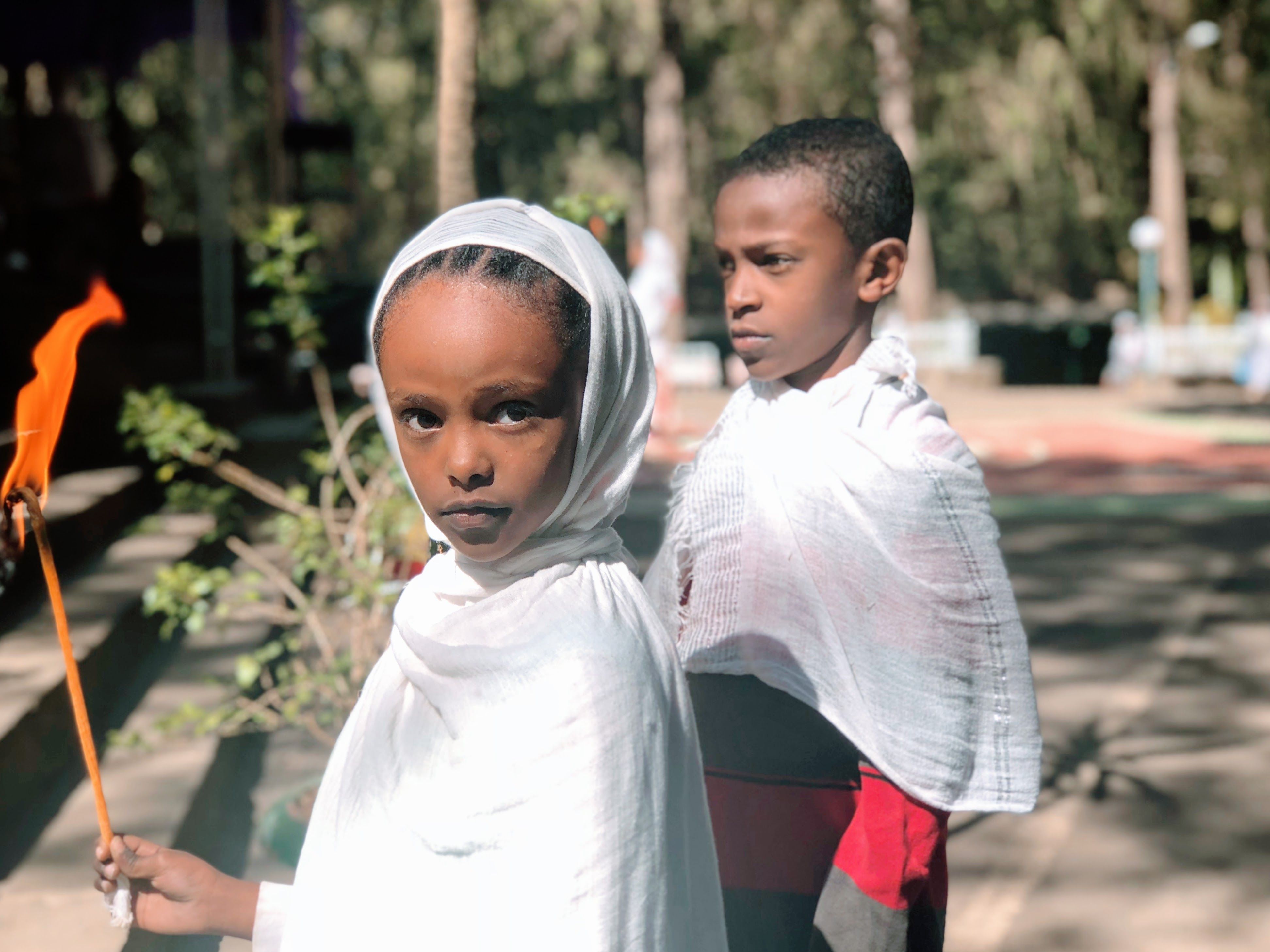 A young girl and boy stand outside of Maryam (St. Mary) Ethiopian Orthodox Church. Image by Arianne Henry. Ethiopia, 2019.
