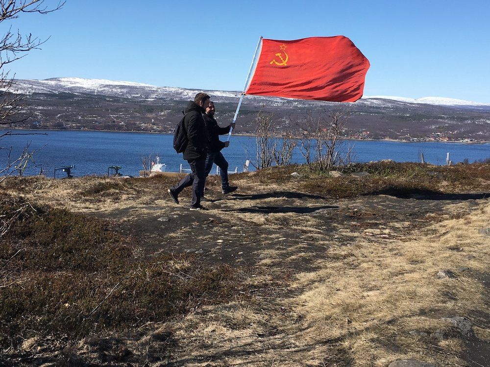 Two men carry a Soviet flag Murmansk, Russia. Image by Amy Martin. Russia, 2018.