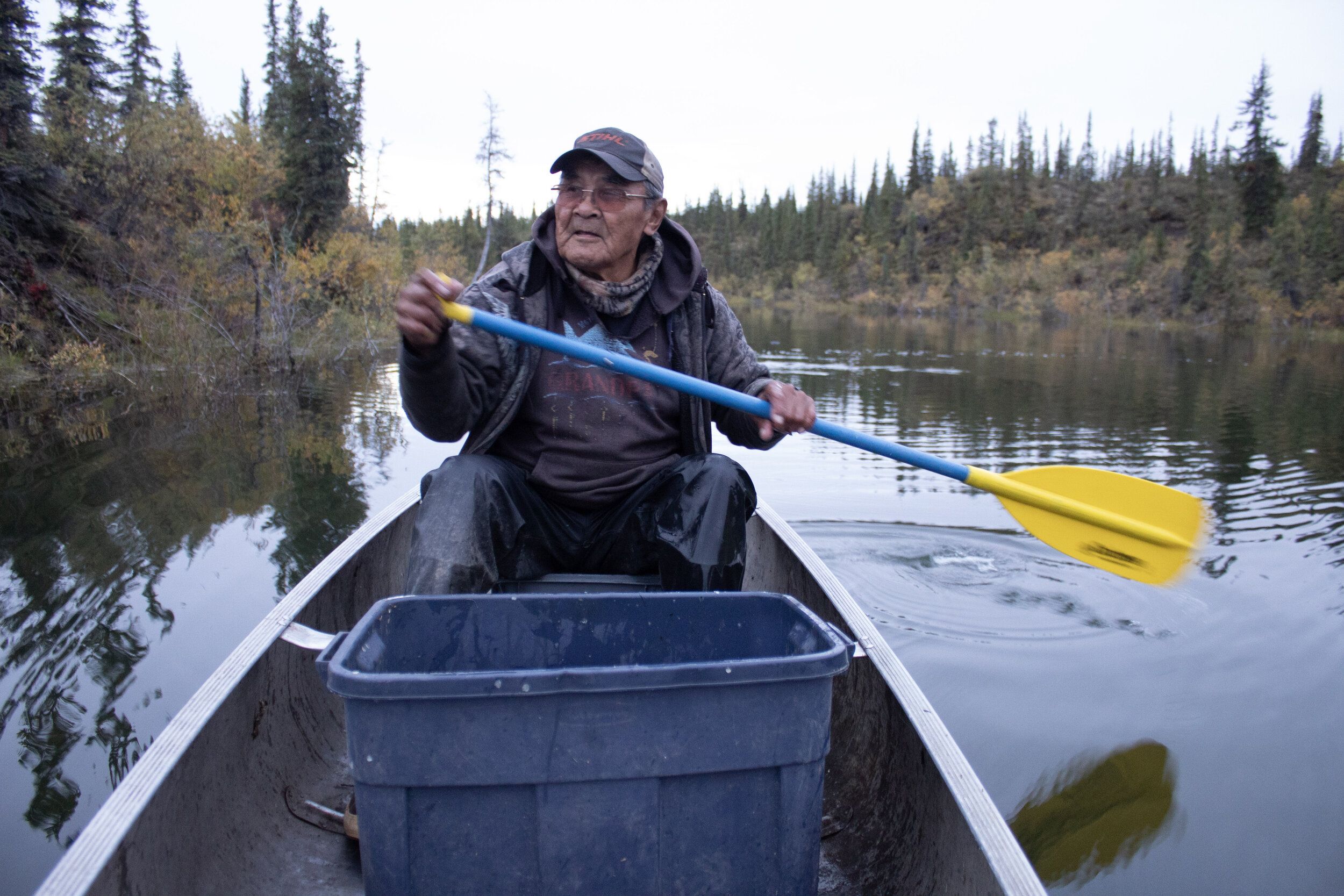 Gideon James rowing out on the creek that runs through Arctic Village. Image by Amy Martin. United States, 2019.