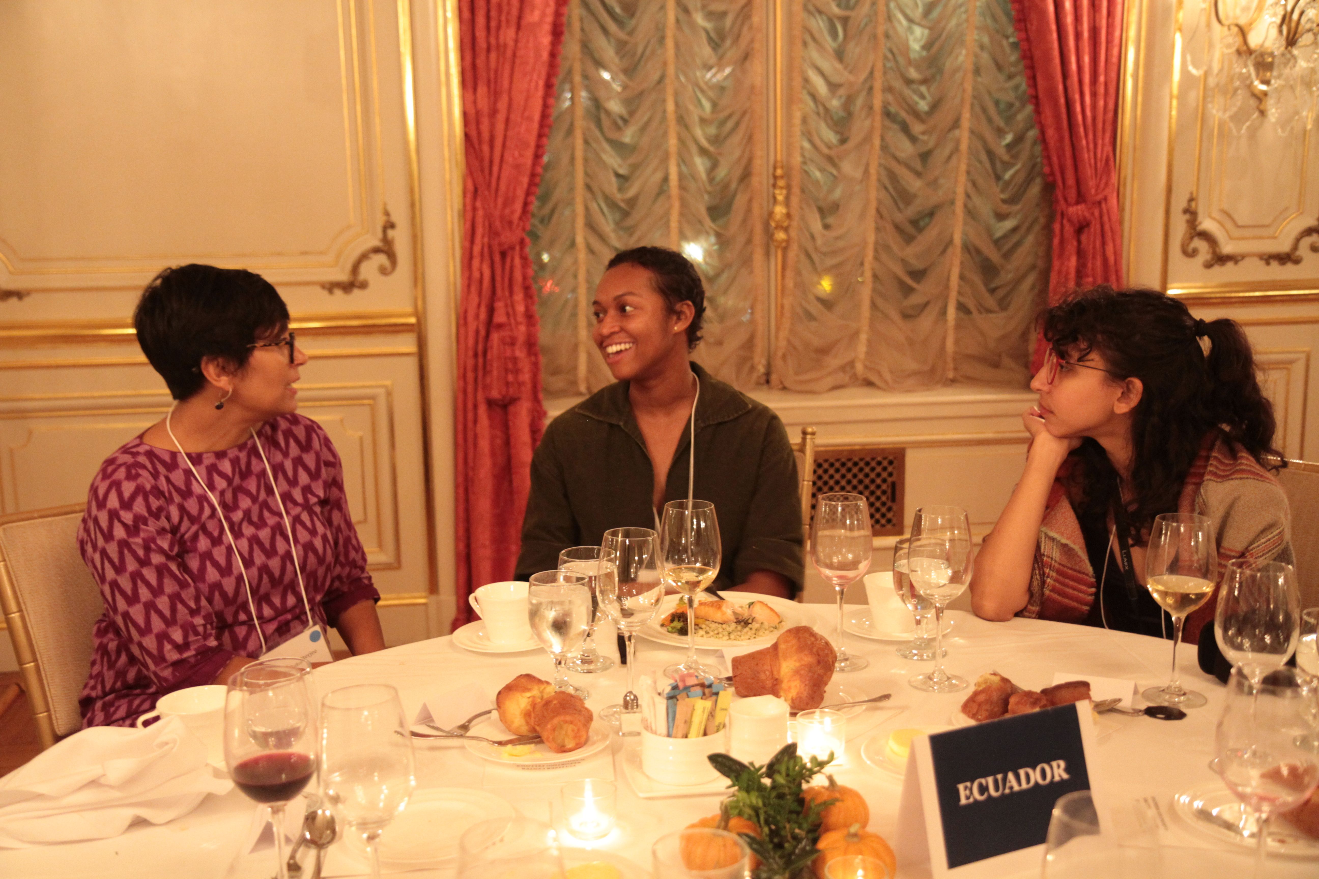 Rhitu Chatterjee, Pulitzer Center grantee, Autumn Harris, Reporting Fellow from Spelman College, and Meerabelle Jesuthasan, education intern at the Pulitzer Center, talk over dinner at the Cosmos Club. Photo by Libby Moeller. United States, 2019. 