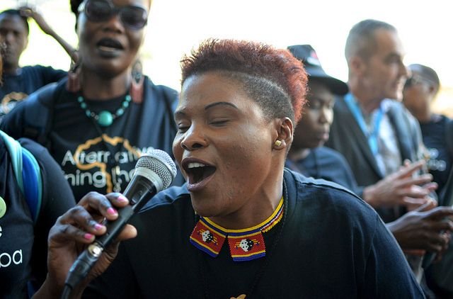 An Alternative Mining Indaba delegate from Swaziland sings protest songs. There was a feeling of triumph among the delegates after achieving even a degree of acknowledgement from industry representatives. Image by Mark Olalde. South Africa, 2017.