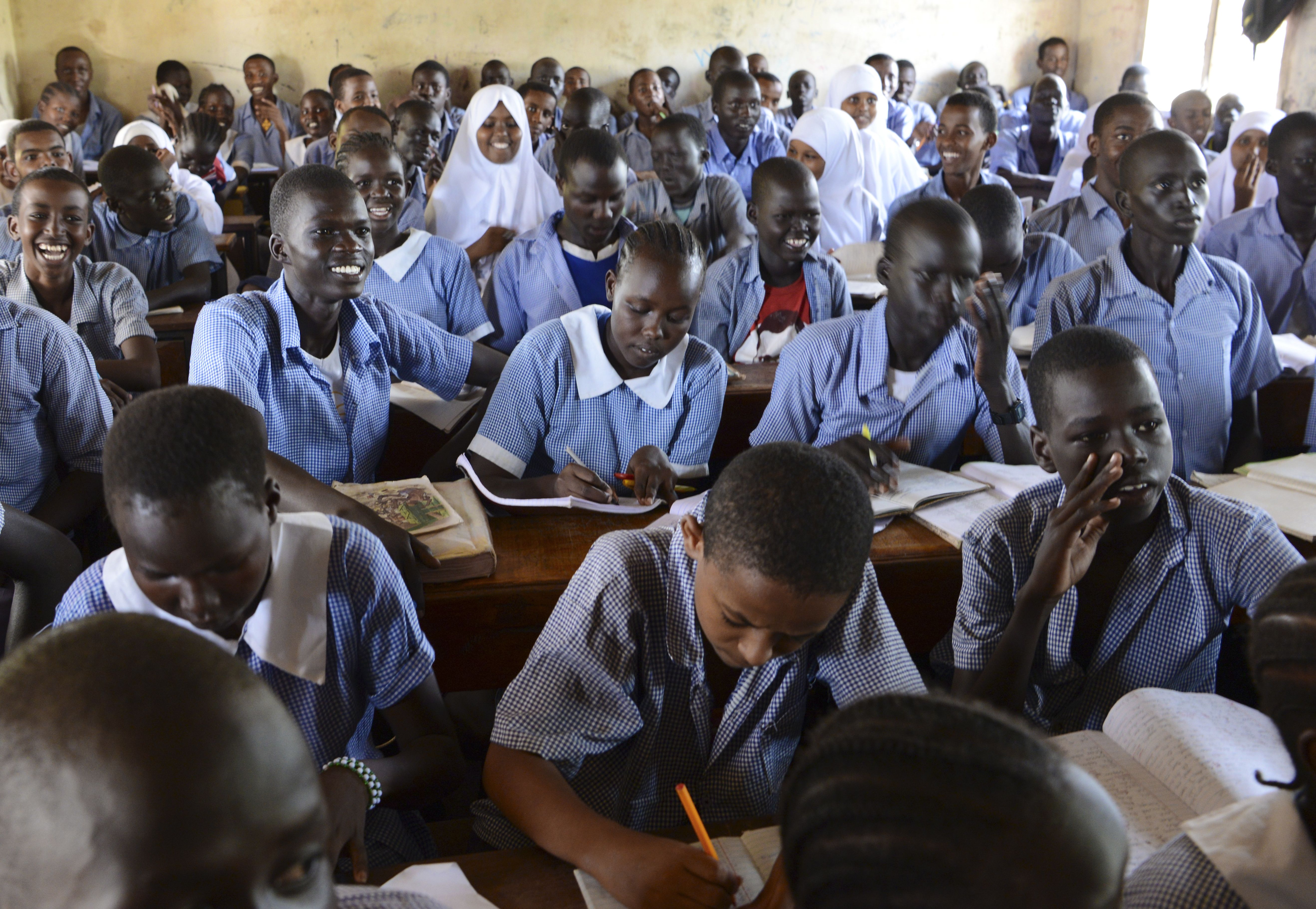 In Kakuma, it is common for students of many ages to learn together in a single classroom. Image by Rodger Bosch for UNICEF USA. Kenya, 2018.