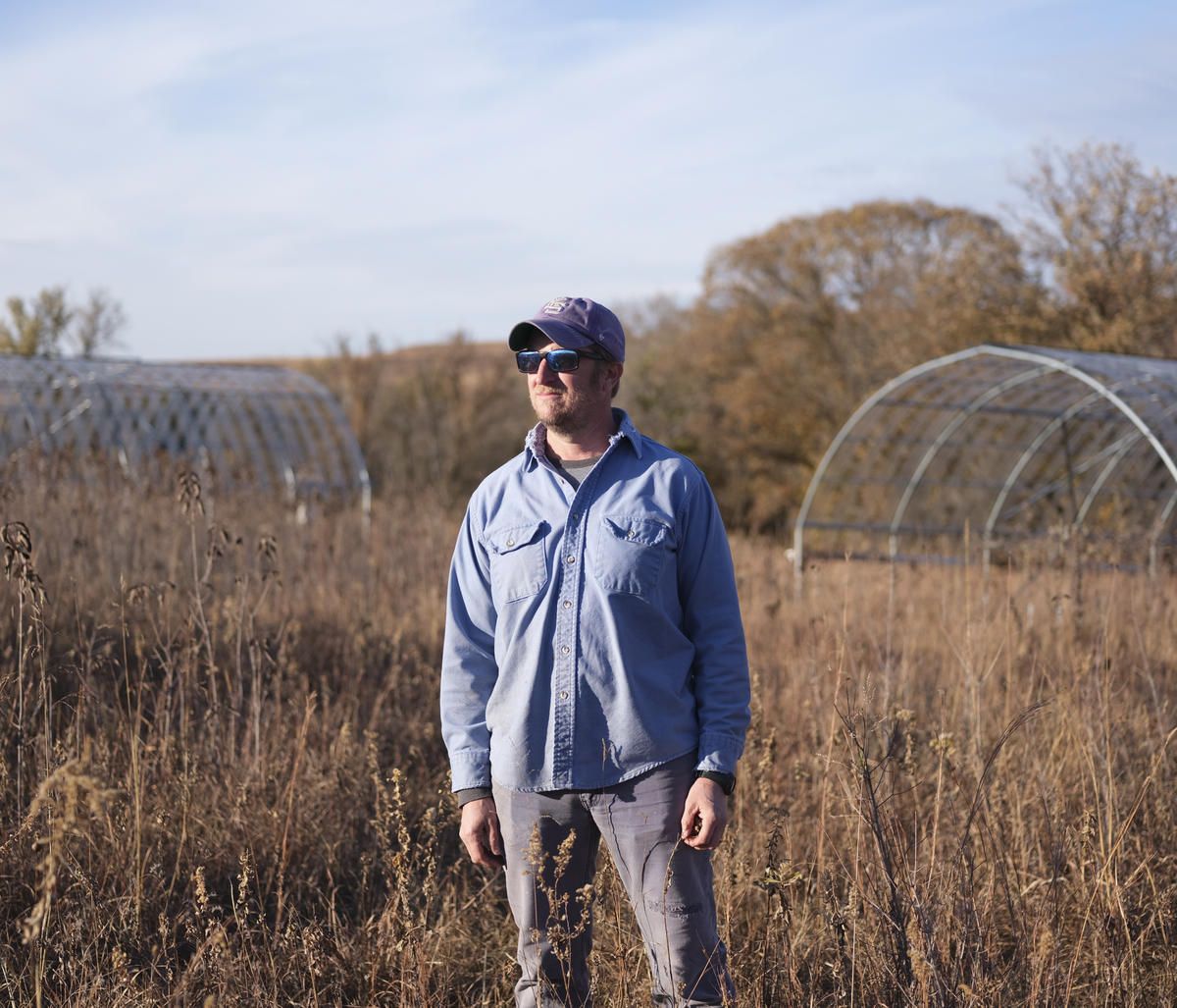 Kansas State University professor Jesse Nippert, pictured with structures that can be used to manipulate sun and rainfall on prairie plots, is the principal investigator of the Konza Prairie Long Term Ecological Research site, which is part of a national network. Image by Kyler Zeleny / For Harvest Public Media. United States, 2020.