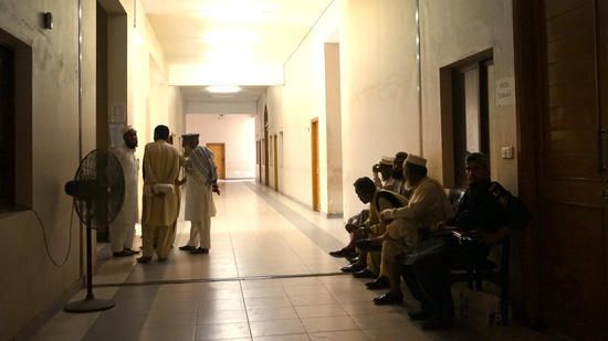 Pakistani tribesmen talk as they wait to enter the FATA Tribunal for a hearing. FATA stands for Federally Administered Tribal Areas. Image by Umar Farooq. Pakistan, 2017.
