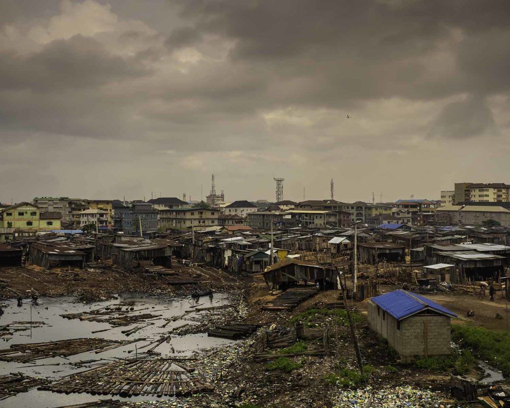In the poorer neighborhoods that ring Lagos, ambient air pollution from traffic and refineries mixes with smoldering trash and cooking fires. Image by Larry C. Price. Nigeria, 2018.