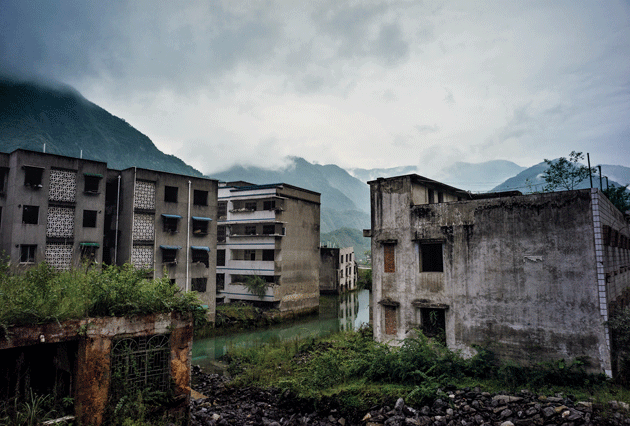 A main thoroughfare in Beichuan, where many buildings sank two floors or more into the ground and the waters of the Jian River. Image by Sim Chi Yin/VII Photo. China, 2015.