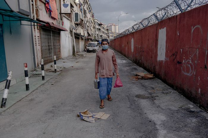 A Rohingya man walks on a back lane of shophouses in Selayang, north of Kuala Lumpur, where many refugees live. Immigration authorities raided the area in May following a coronavirus lockdown. Image by Hasnoor Hussain / The New Humanitarian. Malaysia, 2020.