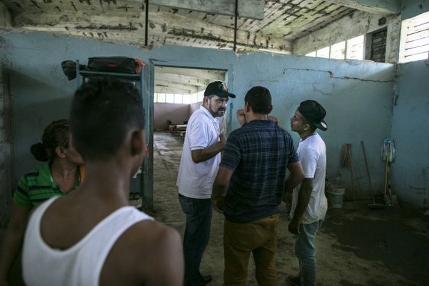 Padre Ramon, the man who first opened Todo por Ellos, speaks with migrants at the shelter. Image by Jose Cabezas. Mexico, 2018. 