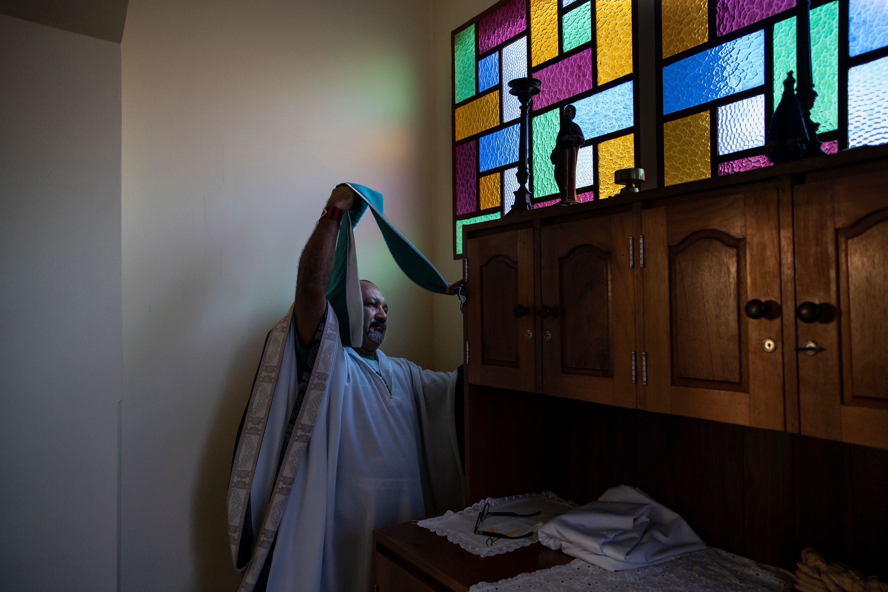 Father Amaro Lopes prepares to celebrate a mass in a chapel at the bishop’s house in Altamira. Image by Spenser Heaps. Brazil, 2019.