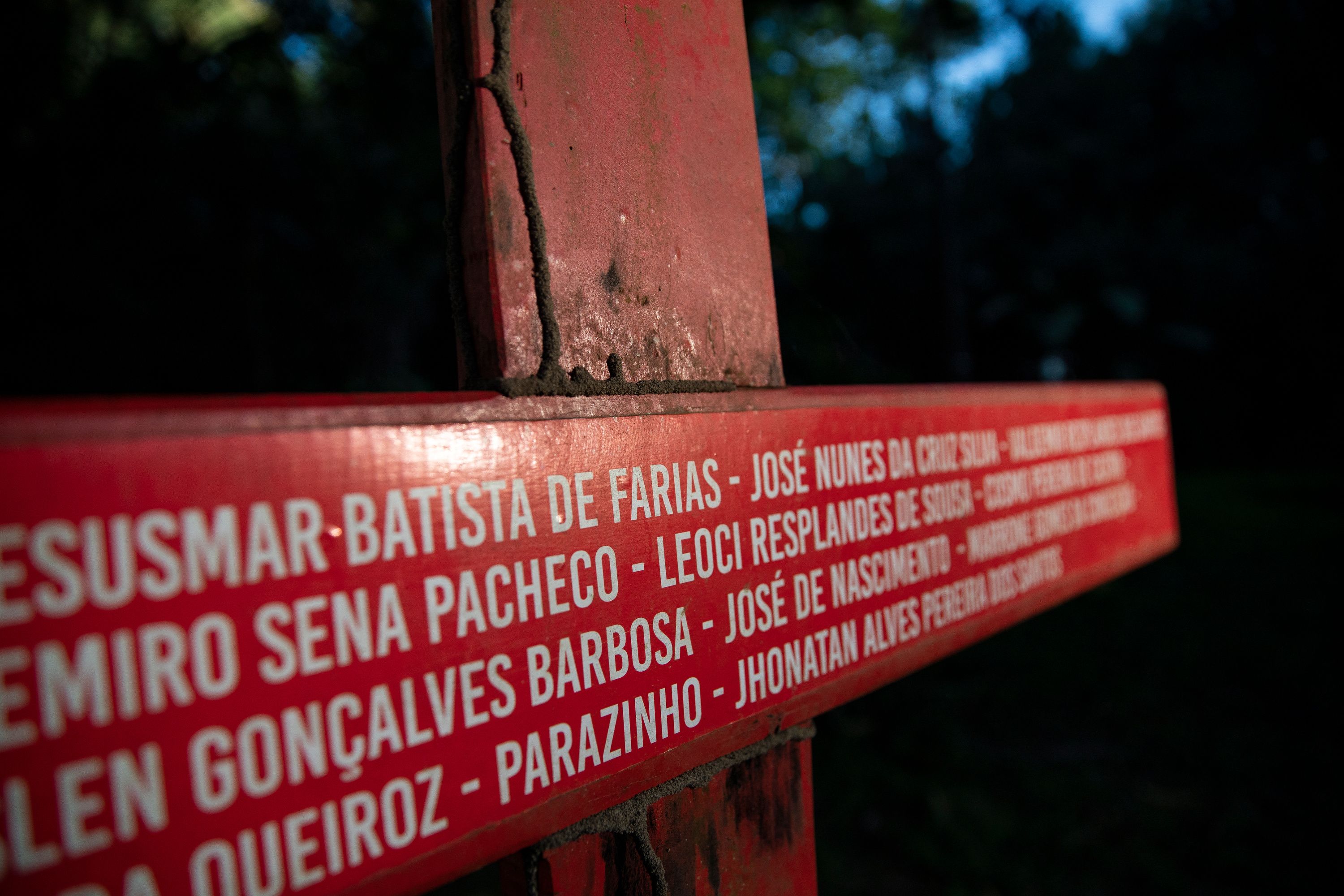 A cross bearing the names of people killed over land conflicts in Anapu stands beside the grave of Sister Dorothy Stang in the Brazilian town. Image by Spenser Heaps. Brazil, 2019.