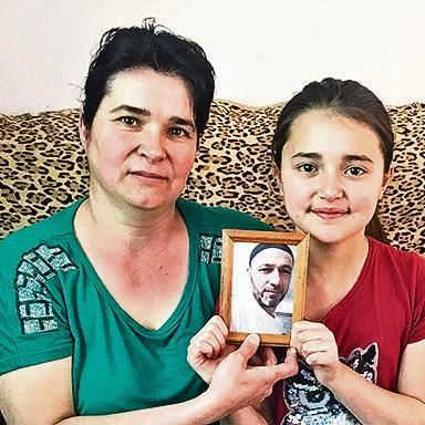 Gulnara Adilova and her daughter Sultaniye with a picture of Bilal, who was arrested at the end of March 29.