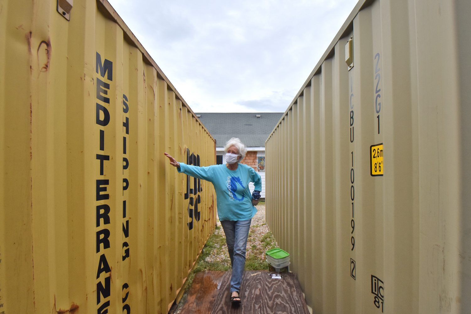 Mickey Baker, co-owner of Mermaid’s Folly, moves between two storage containers holding the contents of her shop on Ocracoke Island. Image by Dylan Ray. United States, undated.