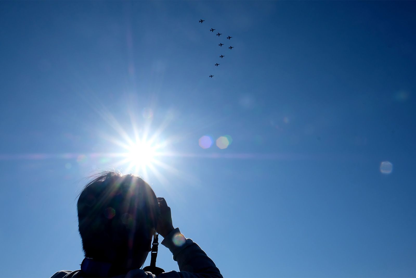 A man captures shots of JASDF planes. Image by Emiko Jozuka. Japan, 2018. 