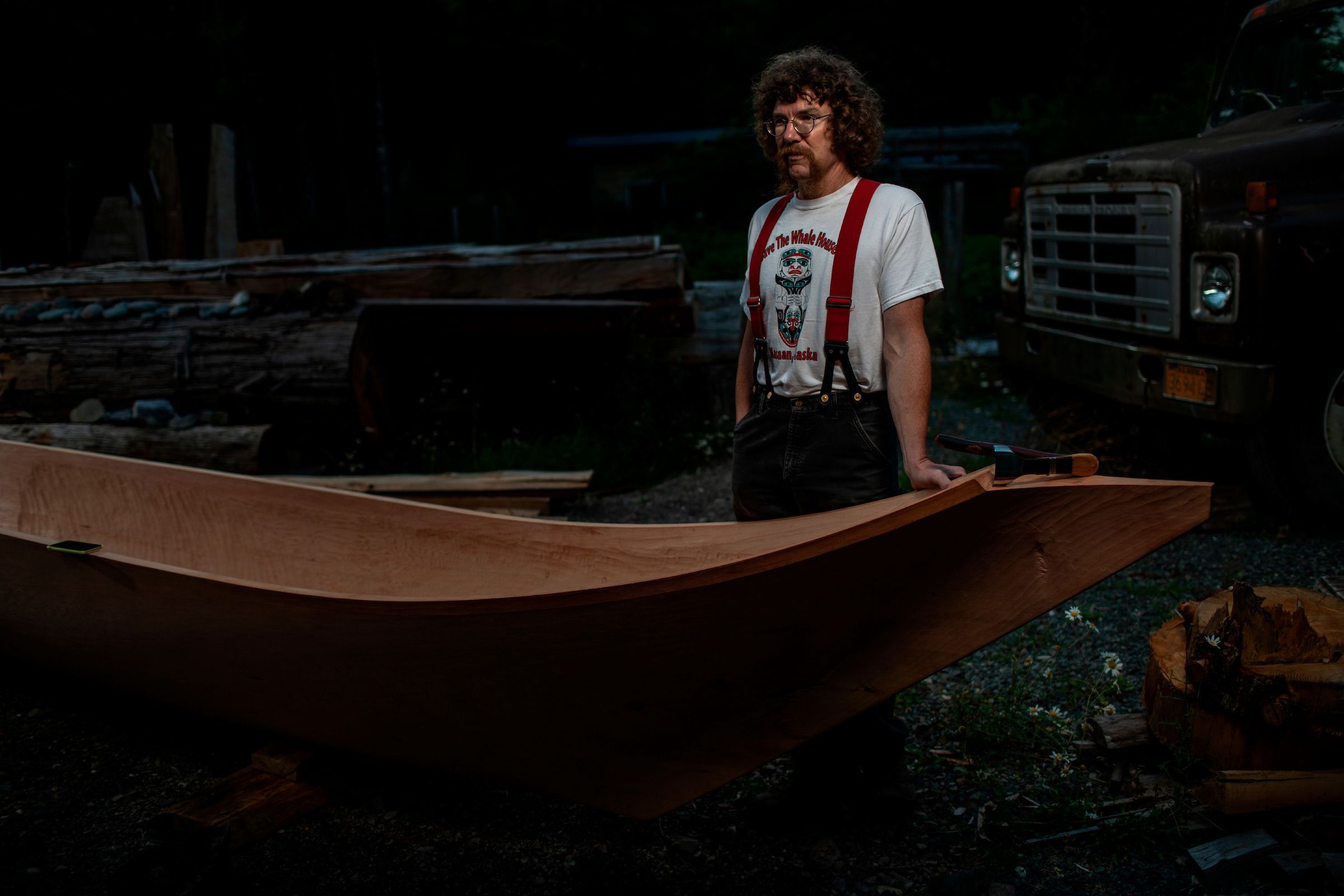 Stormy Hamar, a Haida man, is carving a full-sized canoe using traditional methods. Hamar is one of the few people reviving old techniques. In order to carve a canoe of this scale from a single log, Hamar requires quite large logs, which are becoming difficult to find. Image by Joshua Cogan. United States, 2019.