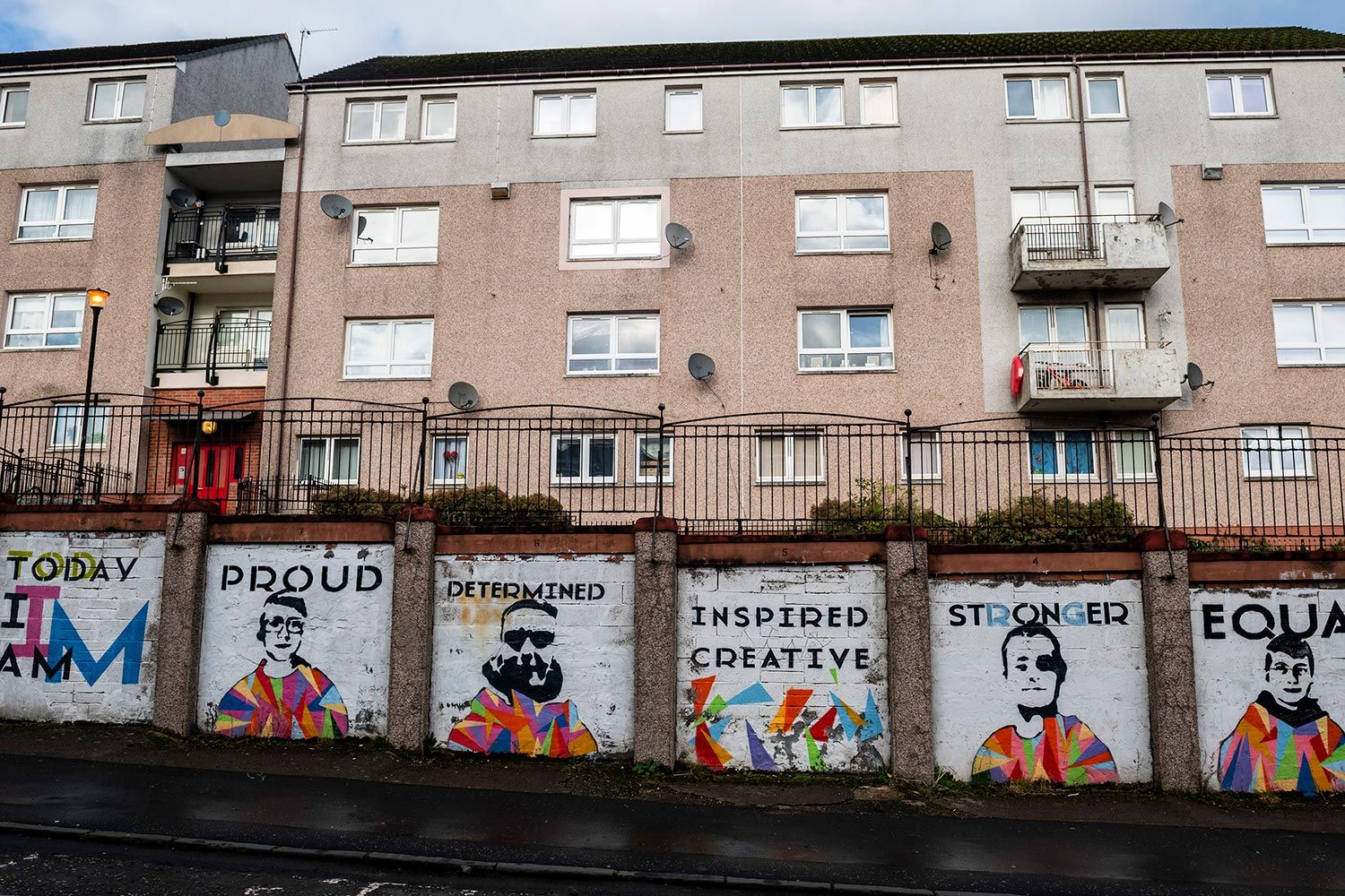 A mural painted by youth from Y Sort It, meant to inspire positivity in the neighborhood, on sealed-off garages, Clydebank. Image by Michael Santiago. United Kingdom, 2019.