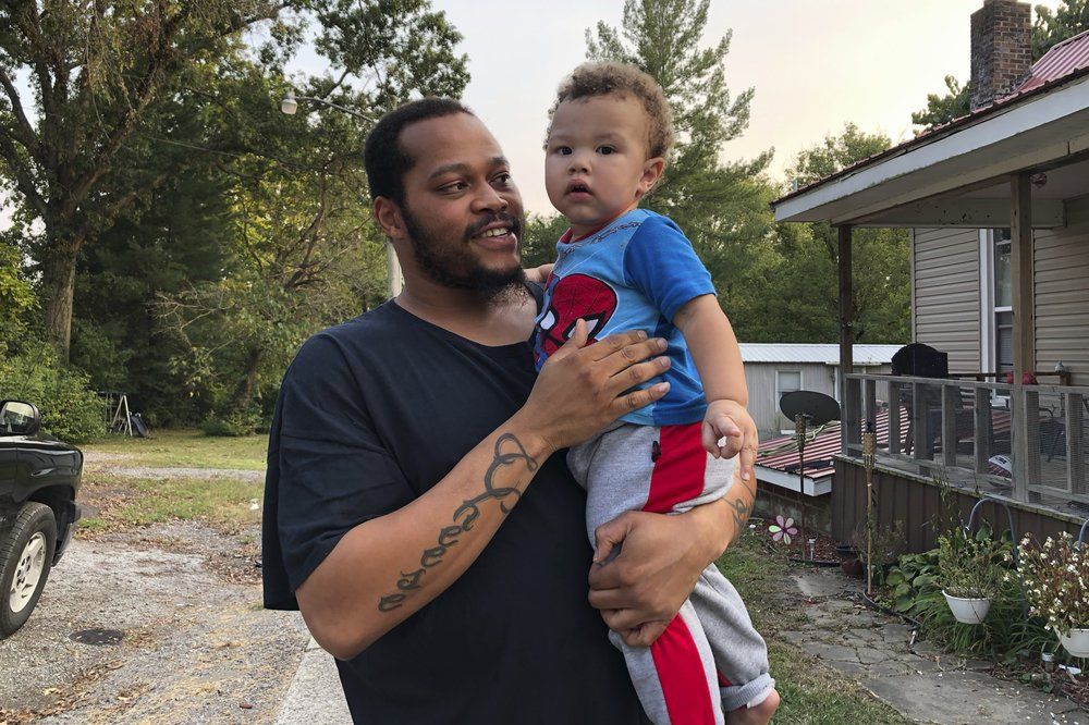 Nicholas Lewis holds son, Nick Jr., near their home in Vienna, Ill. Image by Noreen Nasir/AP Photo. United States, 2020.