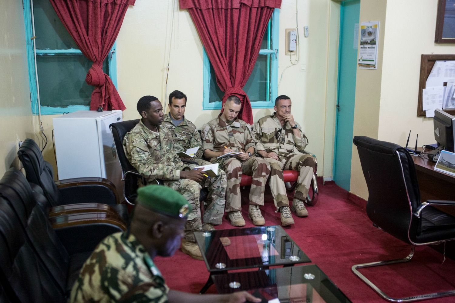 American and French soldiers attend a daily briefing with the Nigerien military commander in charge 
of the fight against Boko Haram at a Nigerien military base in Diffa, Niger. Image by Joe Penney. Niger, 2018.