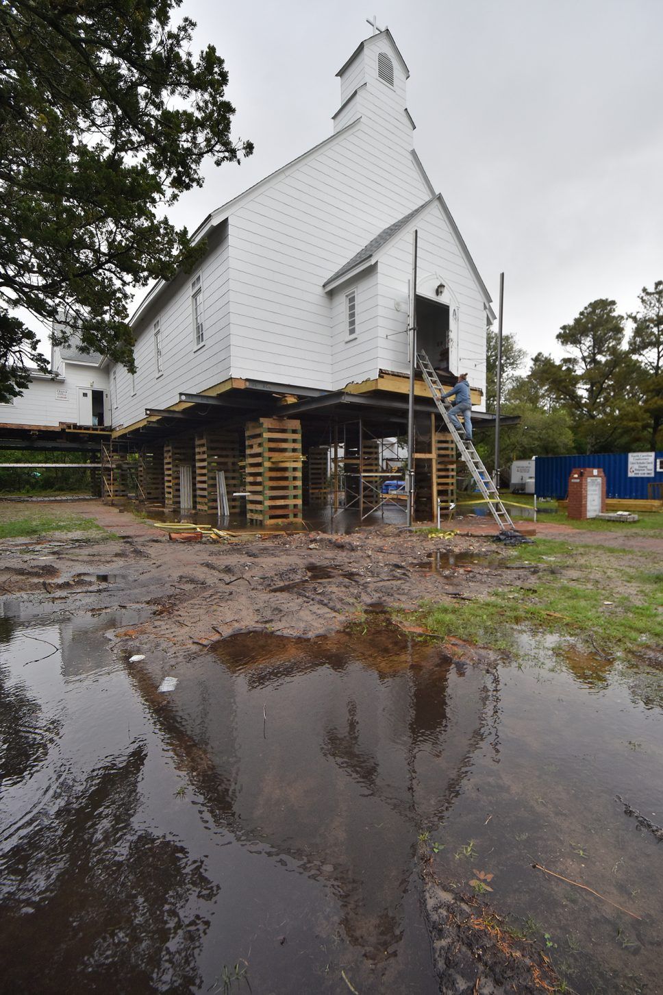 William Adams with Landmark Building and Design descends from the Ocracoke United Methodist Church on School Road where it has been elevated to accommodate storm surge after damage sustained during Hurricane Dorian in 2019. Image by Dylan Ray. United States, undated.
