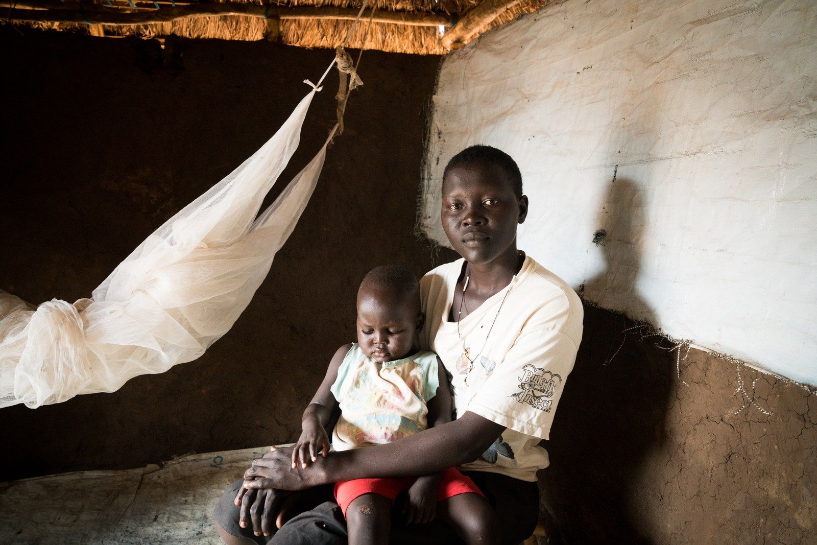Helen Keji, 19, with her son Nicholas, 2, in their home in the Bidi Bidi settlement, June 26, 2019. Image by Adriane Ohanesian. Uganda, 2019.