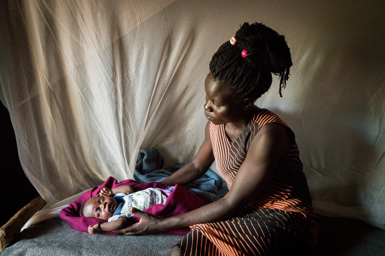 Stella Keji, 18, with her son Nelson in their home in the Bidi Bidi settlement for refugees who have fled from South Sudan to Uganda. Image by Adriane Ohanesian. Uganda, 2019.