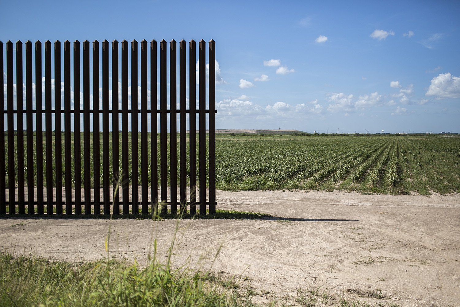 The end of a segment of the border fence near Oklahoma Avenue in Brownsville. To avoid paying for land trapped between the fence and the Rio Grande, the government left wide gaps so land owners could reach their fields. Image by Martin do Nascimento. United States, 2017.
