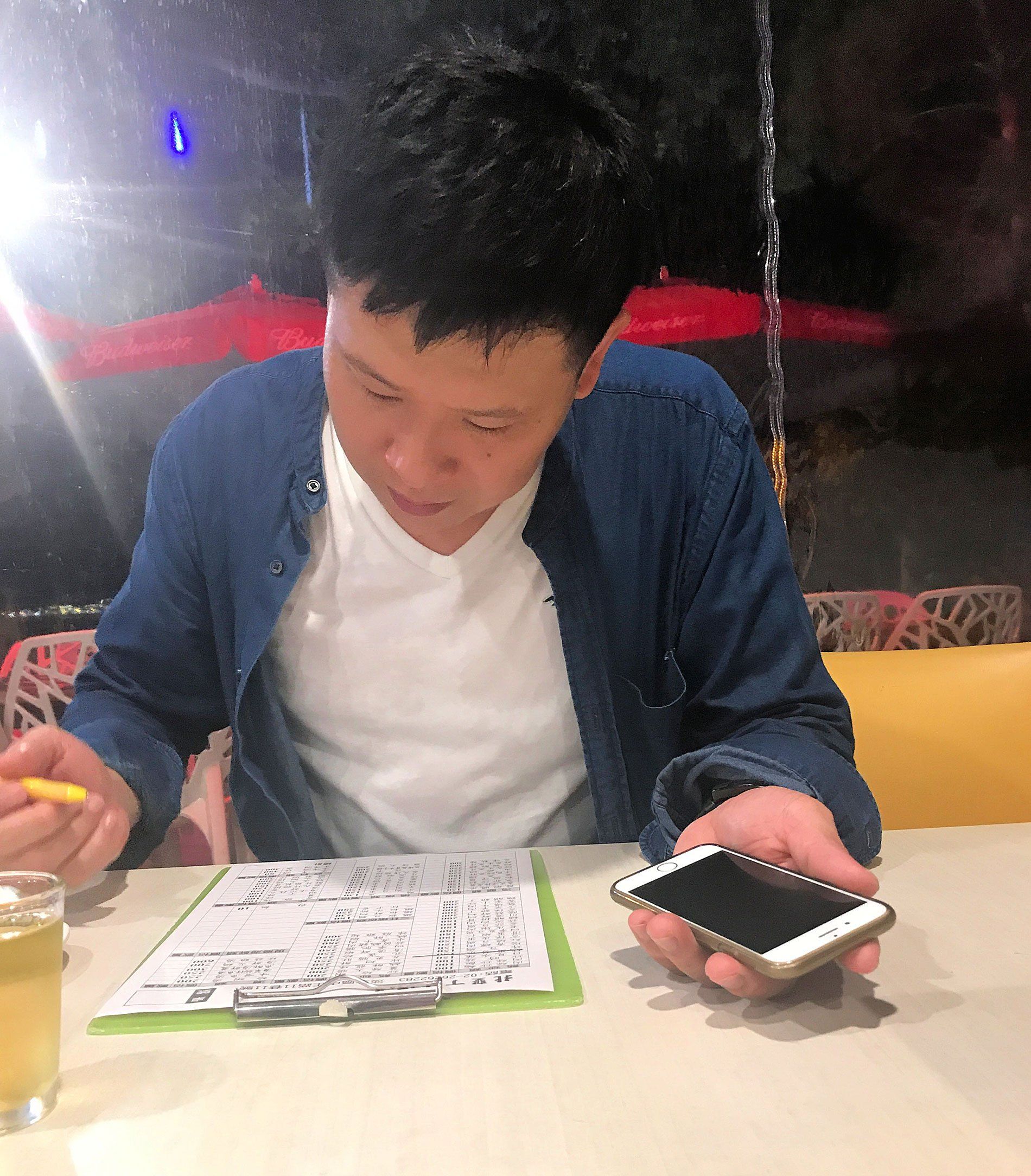 Wei Jiang orders dinner for an English-speaking journalist using his cell phone’s Google Translate app to communicate with her. Image by Melissa McCart. Taiwan, 2018. 