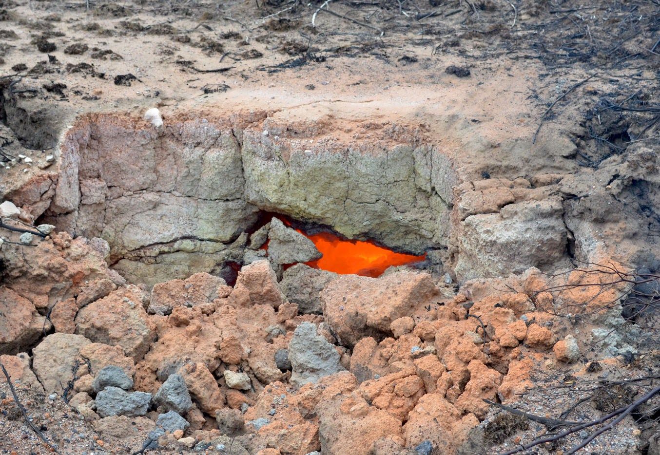 The ground near Anker Coal’s Golfview operation outside Ermelo glows molten orange from an underground fire. Illegal, small-scale coal miners run a profitable operation out of another part of the company’s mine. Image by Mark Olalde. South Africa, 2017. 