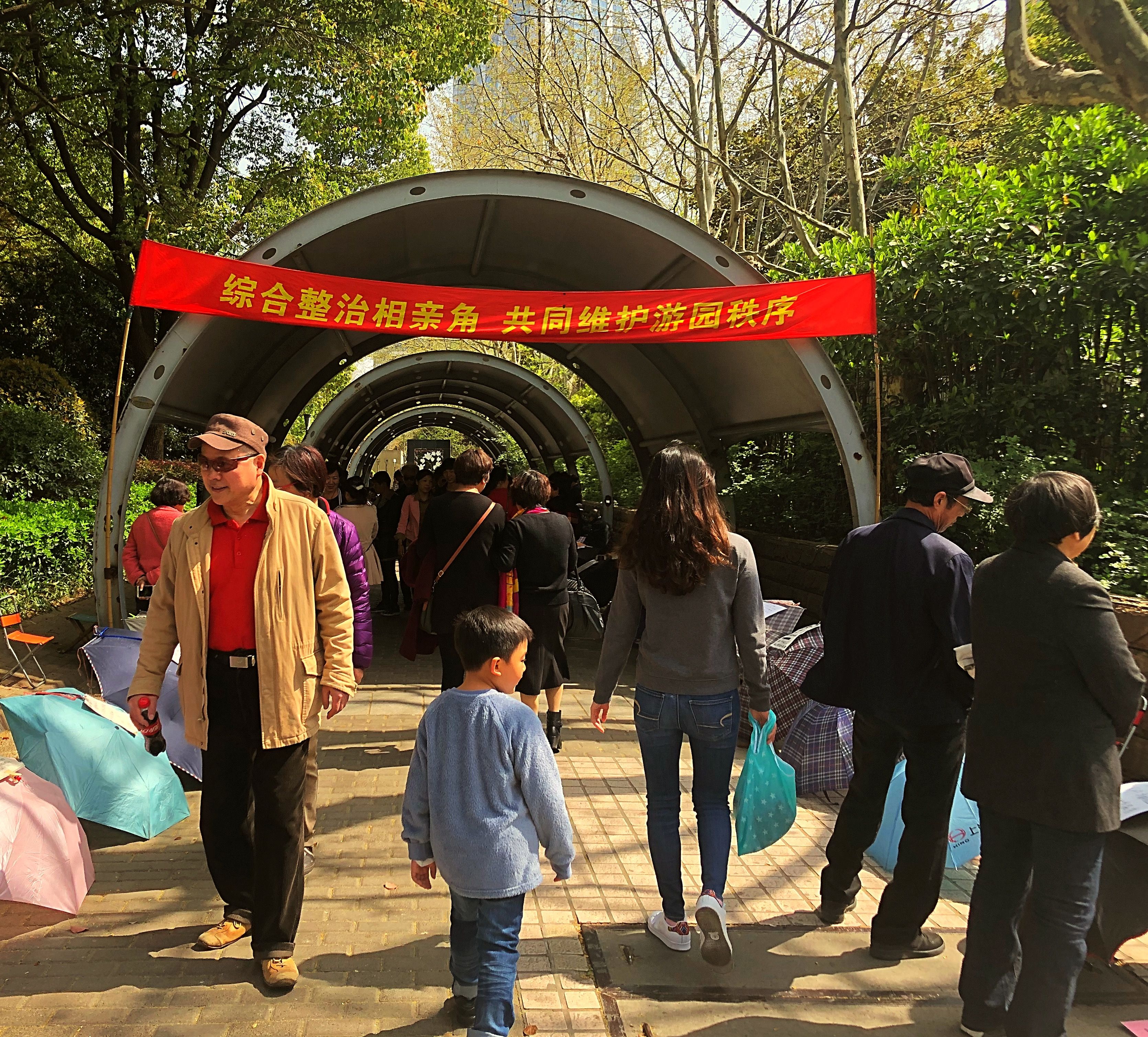 At the marriage market in Shanghai parents post resumes of their children in hopes of finding a spouse for them. The young and their elders read the resumes as they walk through the market. Image by Argentina Maria-Vanderhorst. China, 2018.