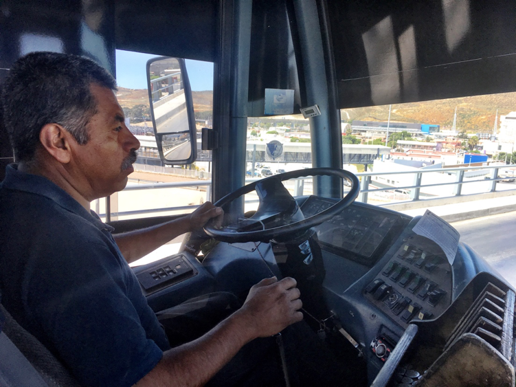 Margarito Cruz Gallarno steers his bus past the San Ysidro Port of Entry. Image by Patrick Reilly. Mexico, 2017.
