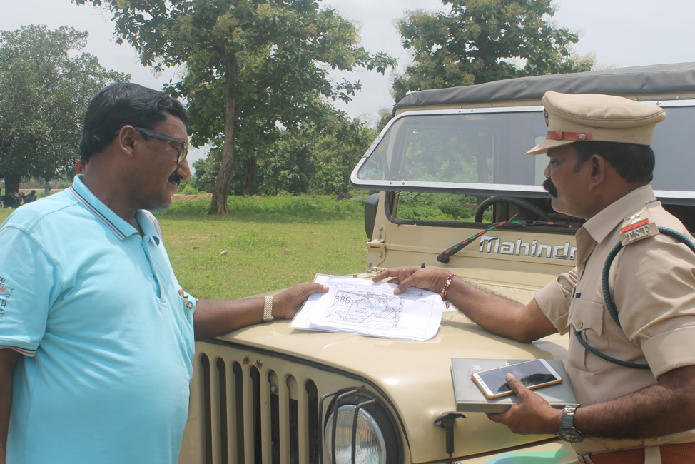 Sherif (left) and another forest reserve officer with the plans for the new village. Image by Vandana Menon. India, 2019.