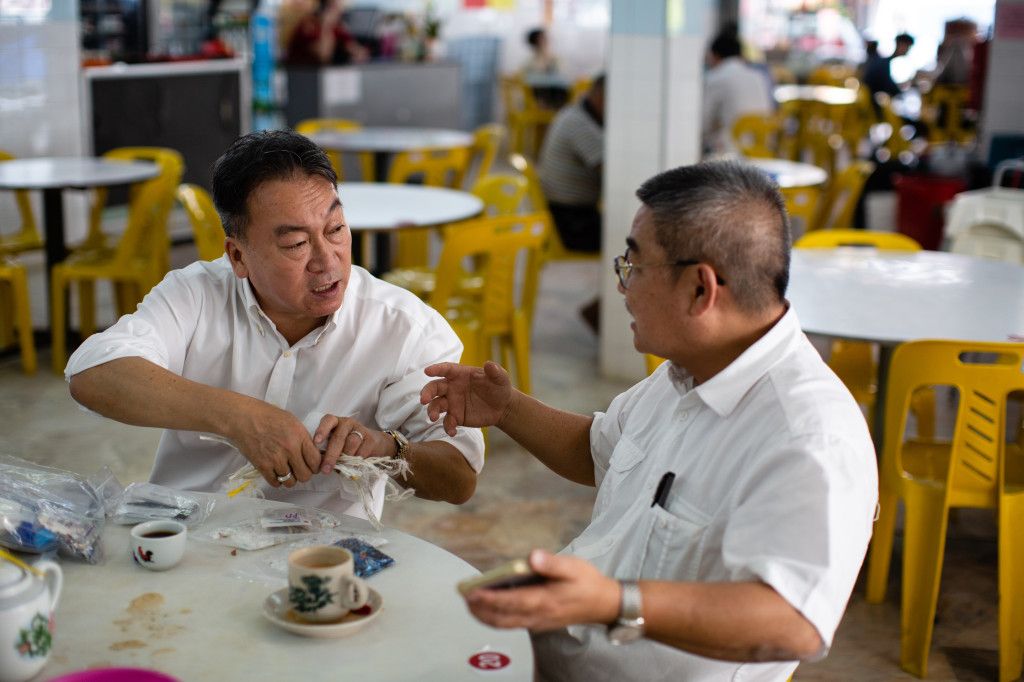 Plastics trader Steve Wong (left) shows plastic samples to recycling-factory owner Saikey Yeong. Image by Sebastian Meyer. Malaysia, 2020.