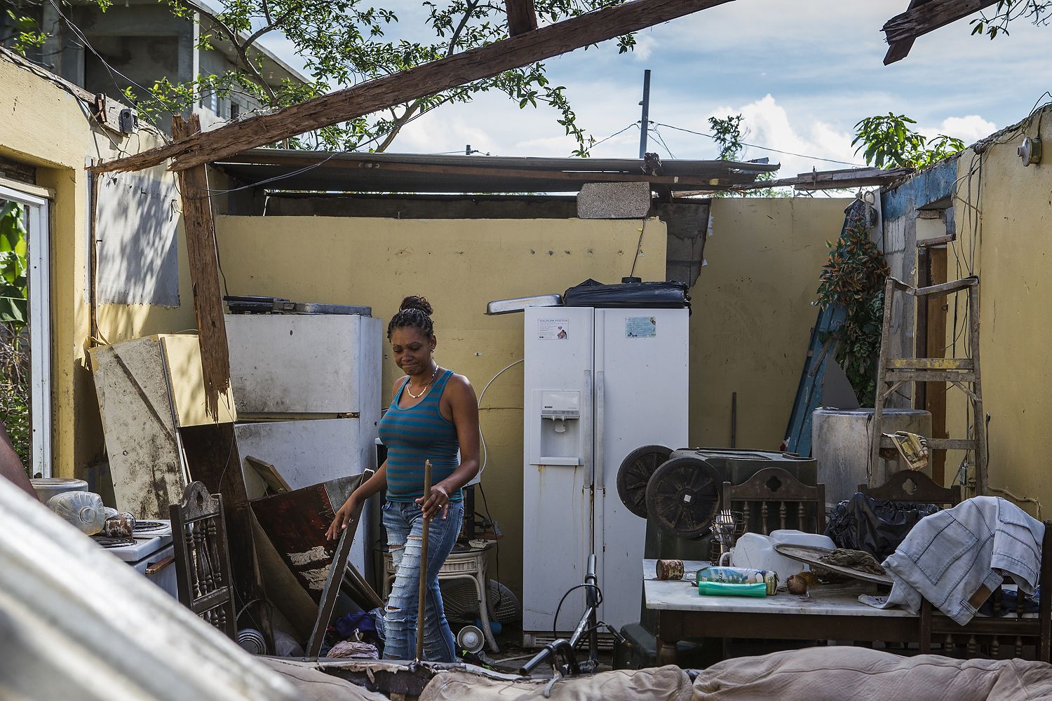 Rosalda Olma, a wife and mother to three kids, sorts through what remains of her home in Loiza. The entire home and contents were destroyed by the hurricane, and the family is living in a nearby school for the time being. “It’s hard getting used to these living conditions,” she said. “All five of us are trying to fit inside a single room.” Image by Ryan Michalesko. Puerto Rico, 2017.