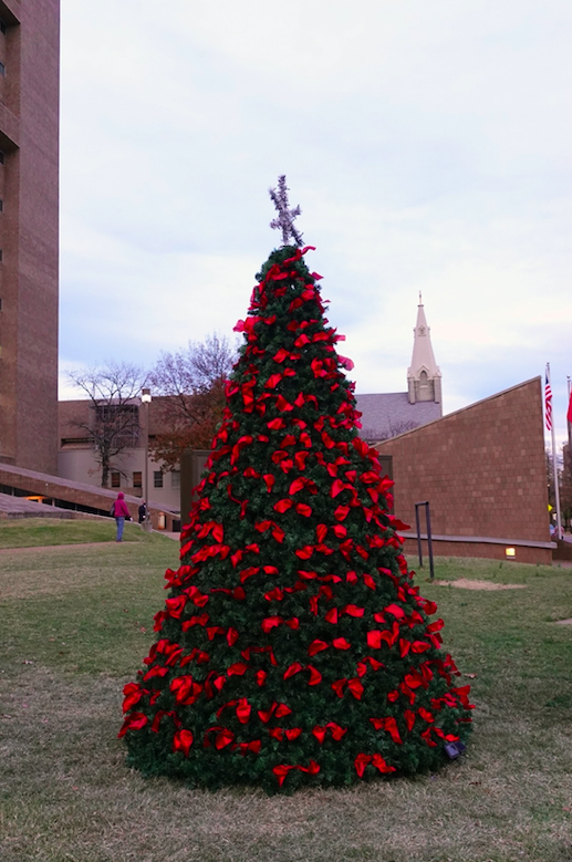 A tree with a ribbon for each Memphis homicide victim in record-setting 2020 has been placed outside the Criminal Justice Center in Downtown Memphis. There now are more than 300 ribbons. Anyone who’s lost a loved one to homicide can hang an ornament on the tree through the end of December. Image by Karen Pulfer Focht/Special to Daily Memphian. United States, 2020.
